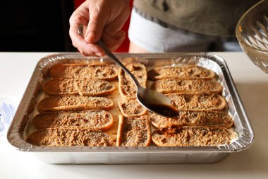 Kadın mutfakta Tiramisu tatlısı yapıyor.