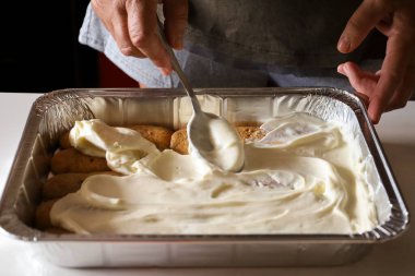 Kadın mutfakta Tiramisu tatlısı yapıyor.