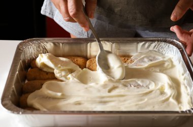 Kadın mutfakta Tiramisu tatlısı yapıyor.