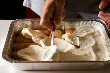 Kadın mutfakta Tiramisu tatlısı yapıyor.