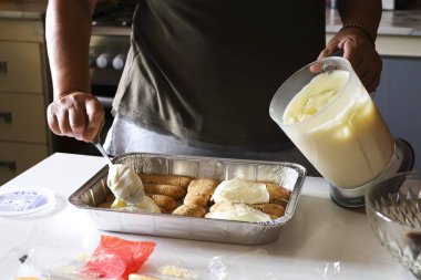 Kadın mutfakta Tiramisu tatlısı yapıyor.