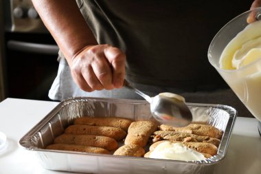 Kadın mutfakta Tiramisu tatlısı yapıyor.