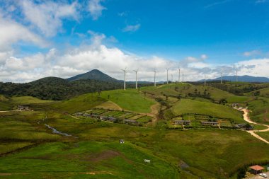 Wind turbines among green pastures and hills. Wind power plant. Ambewela, Sri Lanka.
