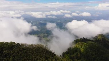 Aerial view of through clouds of mountains with forest and valley with agricultural land. Sri Lanka, Liptons Seat.