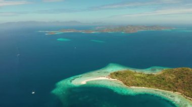 Ditaytayan adasındaki tropikal plajlar. Beyaz kum çubuğu, palmiye ağaçları ve yeşil tepeleri olan tropikal bir ada. Seyahat konsepti. Palawan, Filipinler