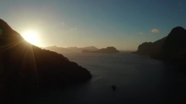 Gün batımında El Nido 'da tropikal havadan izleniyor. Sabahları dağları ve kayalık adaları olan deniz manzarası. Gün batımı gökyüzü ve körfez kayaları. Denizin üzerinde gün batımı