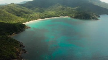 Mavi lagün ve turkuaz suyla körfezdeki güzel tropikal kumsalın hava aracı. Deniz manzarası, kum, palmiye ağaçları. Nagtabon, Palawan, Filipinler. Yaz ve seyahat tatil konsepti