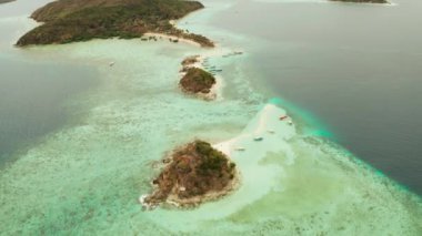 Kum beyazı plajlı tropikal bir ada. Bulog Dos, Filipinler, Palawan. Turkuaz su ve mercan resifli deniz burnu koyunda..