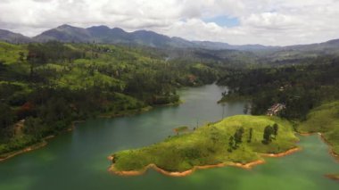 Top view of lake in the mountains surrounded by hills with tea plantations. Maskeliya, Castlereigh, Sri Lanka.