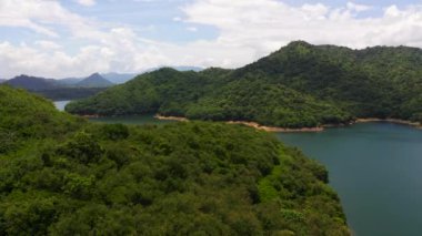 A beautiful lake among the mountains with a green forest. Victoria Reservoir, Sri Lanka.