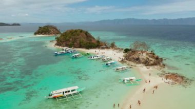 Kum beyazı plajlı tropikal bir ada. Bulog Dos, Filipinler, Palawan. Turkuaz su ve mercan resifli deniz burnu koyunda..