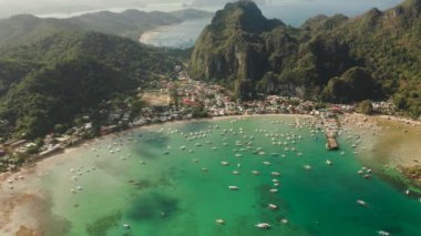 Körfezde mavi gölü ve turist botları olan El Nido kasabası. Hava görüntüsü. Palawan adasında ünlü bir turistik yer. Mavi körfezli deniz burnu ve yukarıdan görünen tekneler. Yaz ve seyahat
