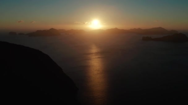 日没時にエルニドの空中ビュー熱帯湾 午前中は山や岩の多い島での海景 日没の空と湾の山の岩 海に沈む夕日 — ストック動画