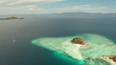 Tropikal adası, kumlu sahili, turkuaz suyu ve mercan resifi olan havadan deniz manzaralı bir koy. Bulog Dos, Filipinler, Palawan. Tropikal adada turist tekneleri.