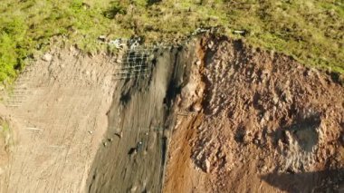 İşçiler dağın yamacını metal ağlarla güçlendirerek kayaların düşmesini ve toprak kaymasını önlüyor. Heyelan önleyici beton duvar inşa eden işçiler kayalara karşı koruma sağladılar