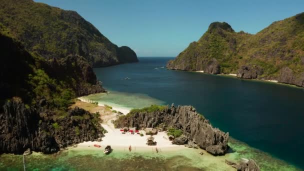 空中无人飞行的热带景观湾 有海滩和清澈的蓝色海水 周围是悬崖 Nido Philippines Palawan 海景与热带岩石岛屿 海洋蓝色的水 夏天和旅行 — 图库视频影像