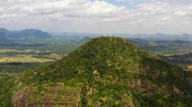 Buddhist monastery on top of a mountain on the background of a valley with tropical vegetation. Sri Lanka.