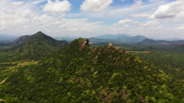 Mountains covered with green forest and valley with jungle against blue sky and clouds. Sri Lanka.