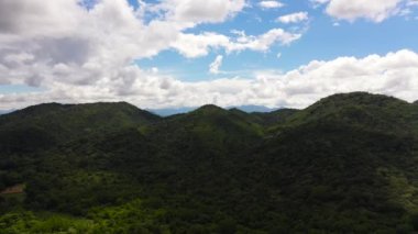 Aerial view of Mountains covered rainforest, trees and blue sky with clouds. Sri Lanka.