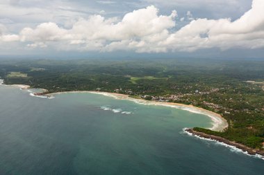 Aerial drone of coast with a beach and hotels among palm trees. Dickwella Beach, Sri Lanka.
