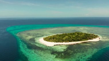 Mavi denizde, mercan resifli tropik bir ada. Kumsallı küçük bir ada. Yaz ve seyahat tatil konsepti, Mantigue Adası, Filipinler, Mindanao