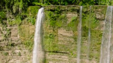 Aerial view of beautiful Niludhan waterfall slow motion in the mountains among the jungle. Negros, Philippines.