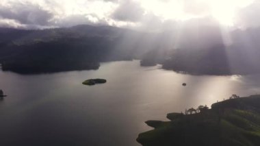 Top view of suns rays on the surface of the lake in the environment of hills in a mountainous area. Maskeliya, Sri Lanka.