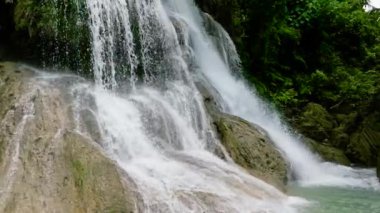 Waterfall in the green forest in slow motion. Lusno Falls in the jungle. Cebu, Philippines.