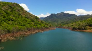 A tropical landscape with a blue lake among the mountain peaks. Kalu Ganga Reservoir.