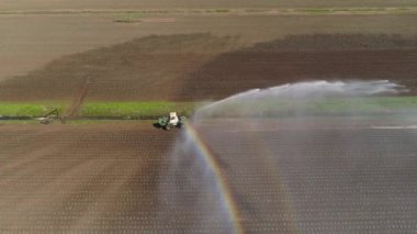 Merkezi pivot fıskiye sistemini kullanarak havadan ekin sulama. Tarım arazilerini sulayan bir sulama rotası. Sulama sistemi tarım arazilerini suluyor.