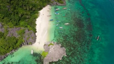 Tropikal manzara: Matukad Adası güzel plajlar ve turkuaz su manzaralı turistler. Caramoan Adaları, Filipinler. Yaz ve seyahat tatili konsepti. Tekneler ve turistler