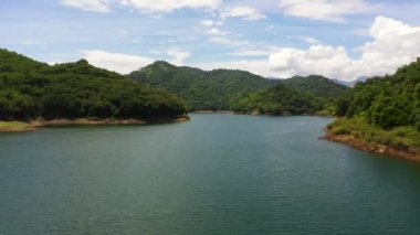 A tropical landscape with a blue lake among the mountain peaks. Victoria Reservoir, Sri Lanka.