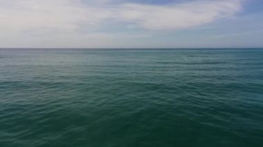 Dalgalı mavi denizin ve bulutlu gökyüzünün havadan görünüşü. Okyanus silüeti.