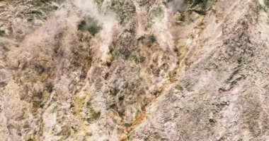 Aerial drone of active volcano with smoke and sulfur gases. Mag-Aso Volcanic Steam Spring. Negros, Philippines.
