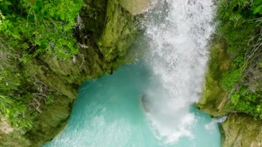Aerial drone of waterfall in slow motion. Inambakan Falls in the green forest. Cebu, Philippines.