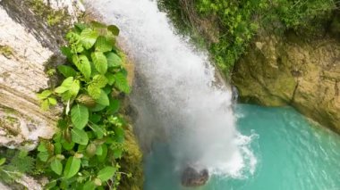 Aerial drone of waterfall in slow motion. Inambakan Falls in the green forest. Cebu, Philippines.
