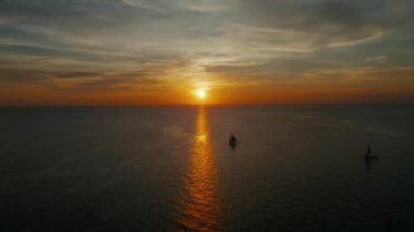 Gün batımında yelkenli tekne silueti, havadan Boracay manzarası, Filipinler. Su yüzeyine yansıyan güneş. Okyanus üzerinde gün batımı. Seascape, Yaz ve seyahat tatil konsepti