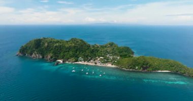 Aerial view of tropical island with a beach. Apo Island. Popular dive site and snorkeling destination with tourists. Negros, Philippines.