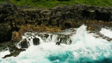 deniz manzarası: mavi okyanus ve sörf dalgaları kayalık kıyı şeridi yavaş hareket, üst görünümü üzerinde çökmesini. Siargao, Filipinler. Yaz ve seyahat tatili konsepti