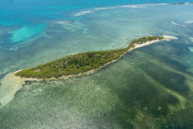 Seascape with tropical island and a sandy beach in the sea. Tanduyong Island, Philippines.