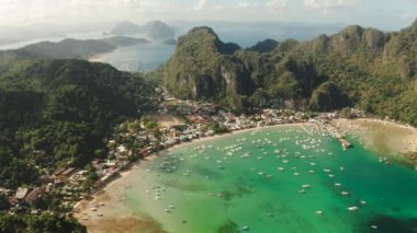 Körfezde mavi gölü ve turist botları olan El Nido kasabası. Hava görüntüsü. Palawan adasında ünlü bir turistik yer. Mavi körfezli deniz burnu ve yukarıdan görünen tekneler. Yaz ve seyahat