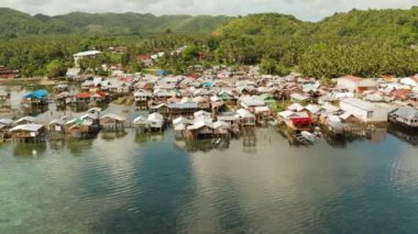 Balıkçı köyünde deniz kenarında duran eski ahşap ev, hava manzaralı. Dapa, Siargao, Filipinler.