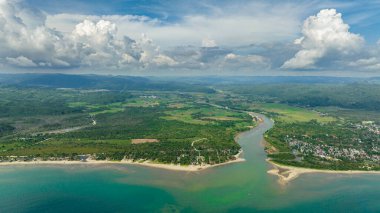 The river flows into the sea and the beach. Tropical landscape. Sipalay, Negros, Philippines.