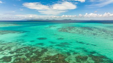 Turquoise lagoon surface and coral reef view from above. Seascape, aerial view.