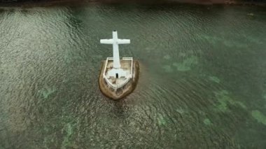 Batık mezarlıkta katolik haçı, gün batımında deniz manzaralı. Batık Mezarlıkta gün batımı Camiguin Adası Filipinleri.