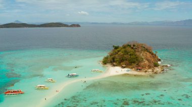 Kum beyazı plajlı tropikal bir ada. Bulog Dos, Filipinler, Palawan. Turkuaz su ve mercan resifli deniz burnu koyunda..