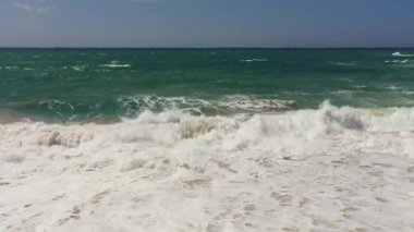 Ocean with waves on a background of blue sky and clouds. Summer and travel vacation concept