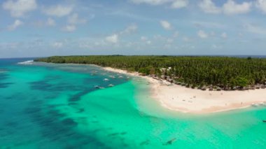 Tropikal bir adada turistler ve teknelerle dolu bir plaj, berrak mavi su. Daco Adası, Filipinler. Yaz ve seyahat tatil konsepti