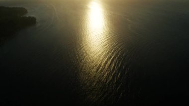 Deniz yüzeyinde gün batımı dalgalarla, hava manzaralı. Su yüzeyine yansıyan güneş. Okyanusun üzerinde gün batımı. Deniz manzarası, yaz ve tatil konsepti