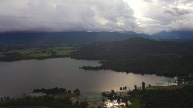 Top view of lake in the valley and mountains covered with forest in the evening.